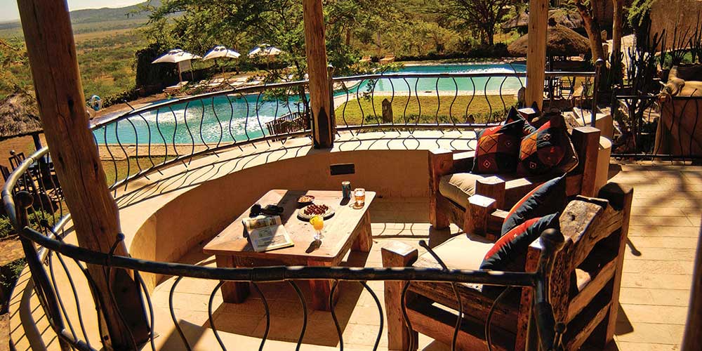 The Serengeti Semi-luxury lodge with wooden sofas and table on a terrace