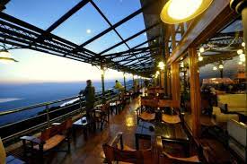 Interior of Ngorongoro Wildlife Lodge with chairs and tables and a beautiful view through a transparent glass